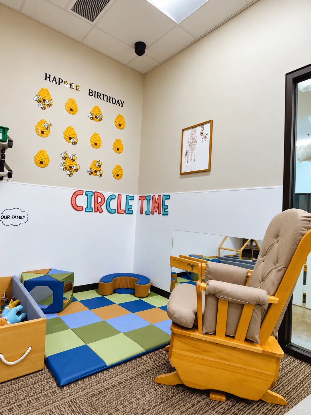 Circle time corner with a rocking chair on a colorful foam mat