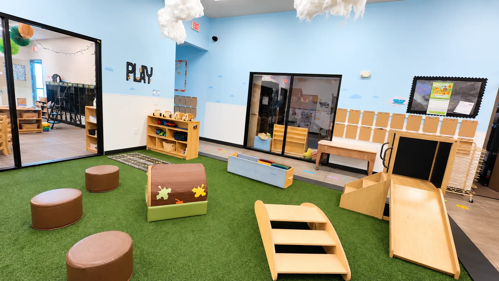 Play area with wooden climber, step ramps, and foam blocks on the turf